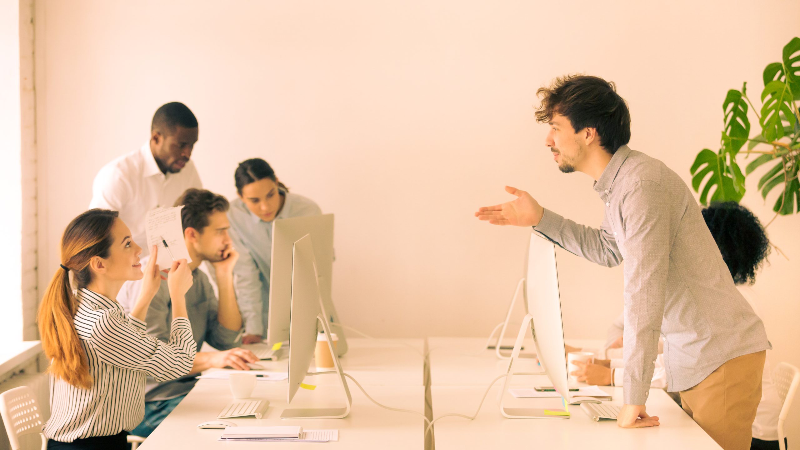 Smiling woman explaining corporate paperwork to new hire in offi