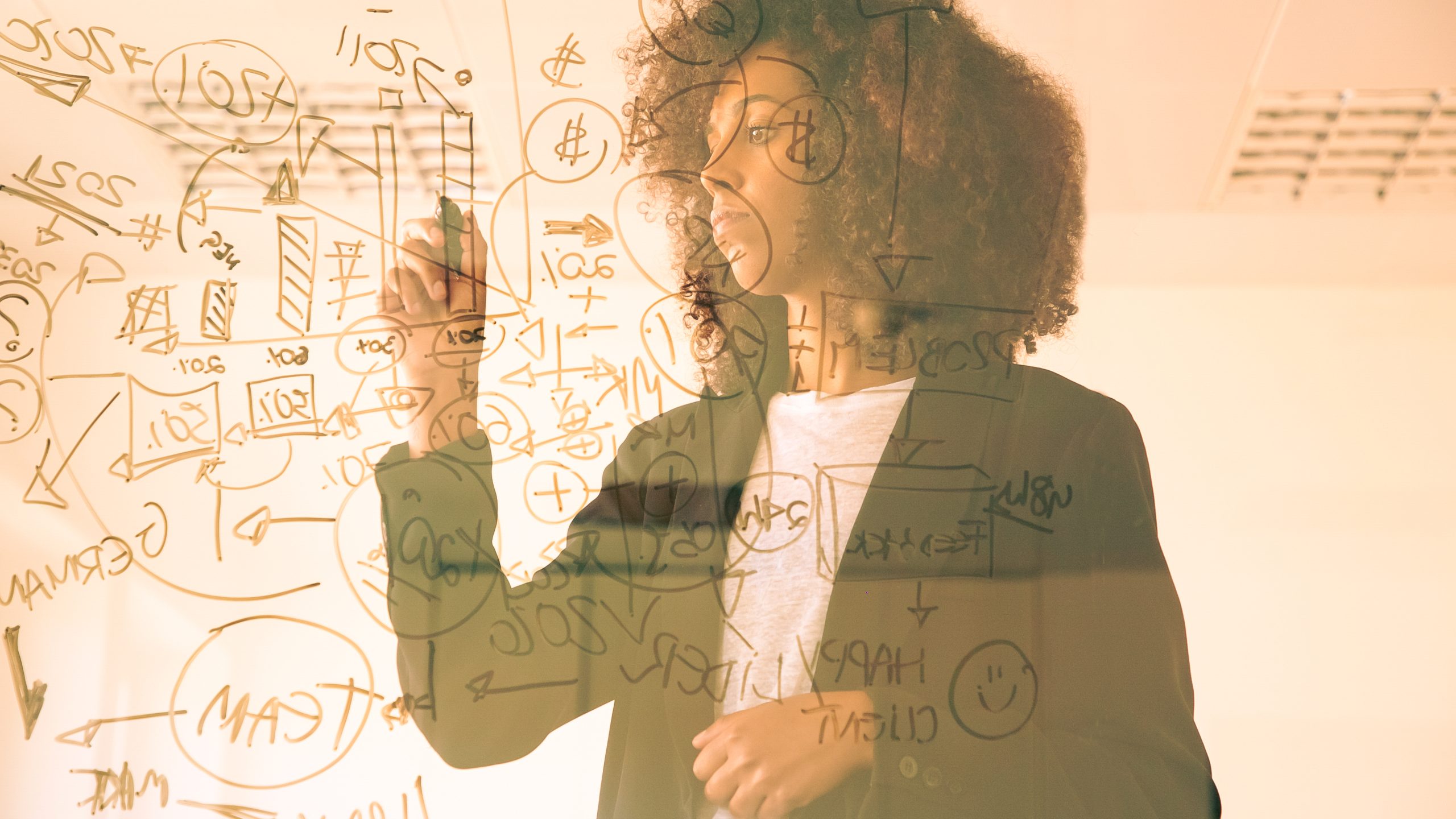Focused young businesswomen writing on virtual board